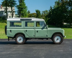 A Classic Land Rover Series III 109 in Light Green with White Wheels. This car is an example of custom car restoration.