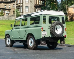 A Classic Land Rover Series III 109 in Light Green with White Wheels. This car has been restored and customized.